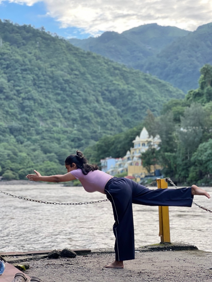 Balancing in warrior three with mountains behind